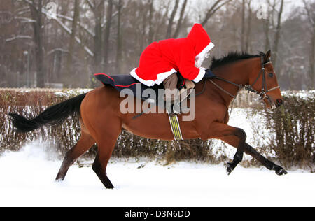 Hoppegarten, Germany, Santa Claus riding on a horse through the snow Stock Photo