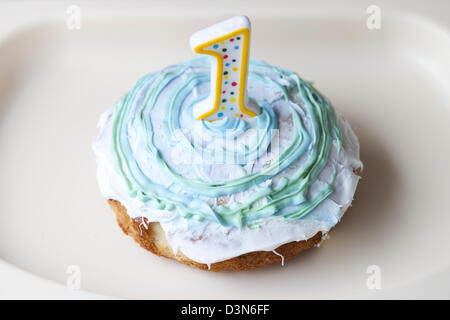 Delicious, gooey smash cake for baby's first birthday. Cupcake with number one candle Stock Photo