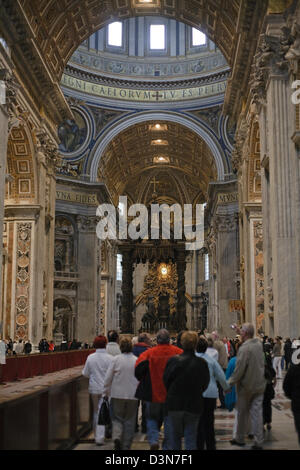 Vatican City, Vatican City, tourists in St. Peter's with papal altar and Bernini's bronze canopy Stock Photo