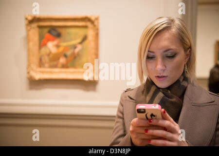 Woman using iphone inside art museum.  National Gallery of Art, Washington DC Stock Photo