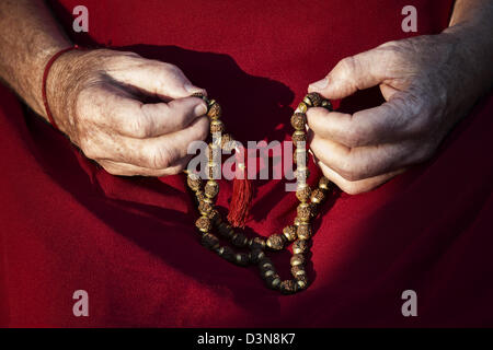 Old mans hands holding Indian Rudraksha / Japa Mala prayer beads Stock Photo