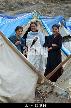 Three young women stand between tents in a refugee camp in Muzaffarabad, Pakistan, Sunday, 29 January 2006. The north-eastern province of Cashmere, Pakistan had been hit by an earthquake of the strength of 7,6 on 8 October 2005. Nearly 80.000 people had been killed, more than three millions were made homeless and suffered severely due to the cold winter. Photo: Wolfgang Langenstras Stock Photo