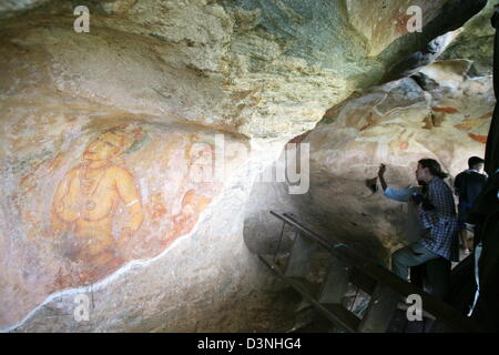 Visitors are amazed by the fresco Cloud Maidens on the rock fortress Sigiryia on Sri Lanka, 27 April 2006. Sigiriya is a 120 metres monolith circa 90 kilometres north of the Holy City Kandy with ruins of a king's fortress dating ennd of fifth century. The frescoes derriving from the same time picture a group of heavenly mymphs (Apsaras) with flowers. Ruin city Sigiriya was listed U Stock Photo