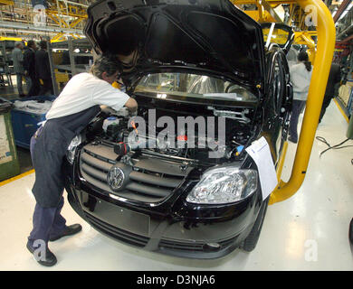 An employee works on a car's engine compartment in the Volkswagen factory in Buenos Aires, Argentina, 03 May 2006. Photo: Tim Brakemeier Stock Photo