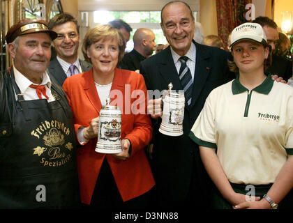German Chancellor Angela Merkel (2nd L) and French President Jacques Chirac (2nd R) pose with waiters after they received beer mugs as present during their summit in the town of Rheinsberg, Germany, 6 June 2006. Merkel and Chirac meet to discuss bilateral and international issues. Photo: Arnd Wiegmann