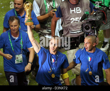 Italian team captain Fabio Cannavaro (C, with trophy) and his team-mate Alessandro del Piero (R) celebrate after the 2006 FIFA World Cup Final Italy vs France at the Olympic Stadium in Berlin, Germany, Sunday 09 July 2006. Italy won 5-3 after penalty shoot-out. DPA/PETER KNEFFEL +++ Mobile Services OUT +++ Please refer to FIFA's Terms and Conditions. +++(c) dpa - Report+++ Stock Photo