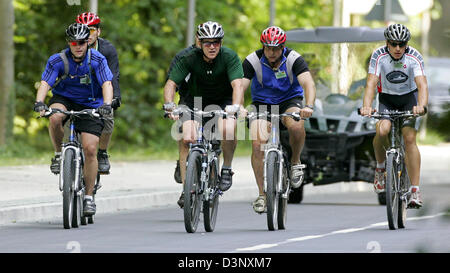 US President George W. Bush (M, green jersey) rides mountainbike in Heiligendamm, Germany, Thursday, 13 July 2006. Bush is accompanied by several security agents on bikes and nearly a dozen of black limousines. The tour took about 45 minutes through the woods near Heiligendamm, where Bush resides during his visit in Mecklenburg-Vorpommern from 12 July to 14 July 2006. Photo: Jan Wo Stock Photo