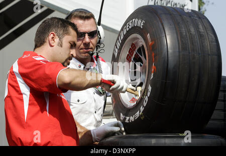 A mechanic of the Scuderia Ferrari checks the pressure of a racing tyre before the first practice session to the FORMULA 1 Grand Prix of France 2006 at the Magny Cours race track near Nevers, France, Friday, 14 July 2006. The Grand Prix fo France will be held on 16 July 2006. Photo: Rainer Jensen Stock Photo