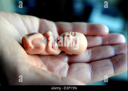 Tiny baby foetus doll held in palm of hand used by anti abortion campaigners