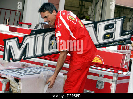 A Ferrari mechanic removes a 'Michael Schumacher' sign in the pitlane after the Formula One Turkish Grand Prix in Istanbul, Turkey, Sunday, 27 August 2006. Photo: Rainer Jensen Stock Photo