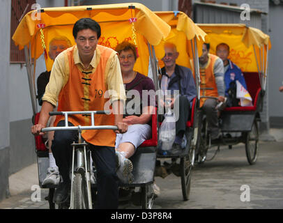 Rickshaws with tourists pictured in a traditional residential quarter, a so-called Hutong, of Beijing, China, 25 September 2006. Most of the Hutongs have been demolished to make room for new buildings. But some of the popular tourist destinations are under monumental protection and were restored. Photo: Alexander Becher Stock Photo