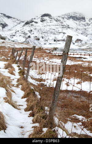 Old Barbed wire fence Coniston Copper Mines in winter with snow on the fells, Lake District, UK Stock Photo