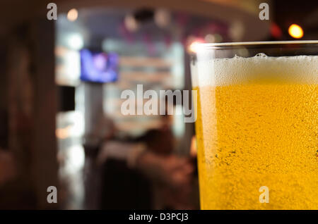 Beer mug with froth on a table in bar