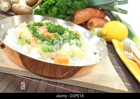 chicken frikassee with rice, peas, mushrooms and parsley in a pan Stock Photo