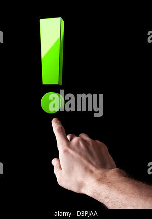 Man's hand shows big green exclamation mark isolated on black background Stock Photo