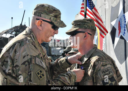 US Gen. Raymond Odierno, the Chief of Staff of the Army, pins Spc. Shawn Gravens with a Purple Heart February 22, 2013 at Forward Operating Base Masum Ghar, Afghanistan. Stock Photo