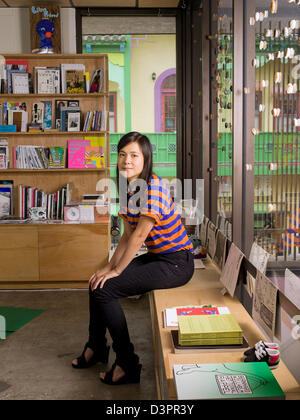 Portrait of a woman sitting in an art book store Stock Photo