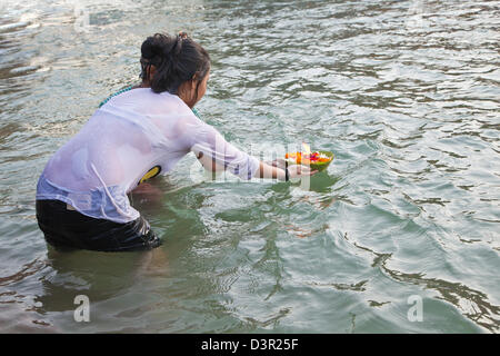 Woman taking holy dip and performing rituals in River Ganges, Haridwar, Uttarakhand, India Stock Photo