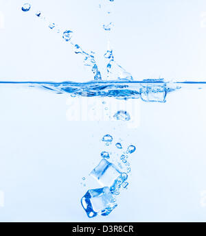 Ice Cubes Dropped into Water with Splash on white Stock Photo