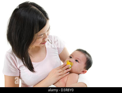 Asian mother trying to calm her crying baby boy isolated on white background Stock Photo