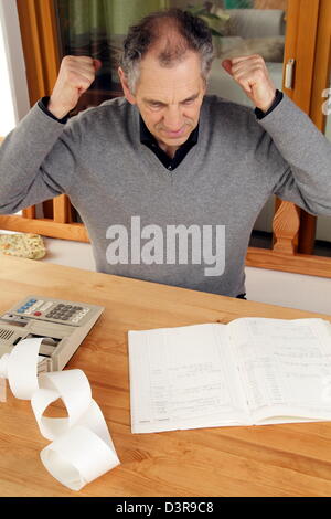 Elder man with calculator and booklet Stock Photo