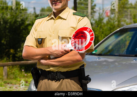 Police - policeman or cop in uniform stop car in traffic control Stock Photo