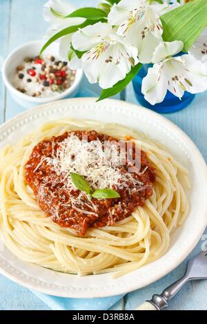 Spaghetti with bolognese sauce and cheese in a rustic plate on an old wooden background. Stock Photo