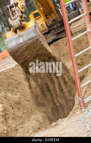 an excavator digging a trench at a construction site, top view from a ...
