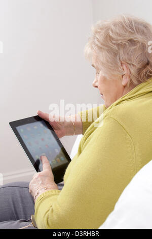 Mature lady using a digital tablet. Stock Photo