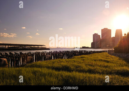 Sunset view of Statue of Liberty and Lower Manhattan from Brooklyn Pier Stock Photo