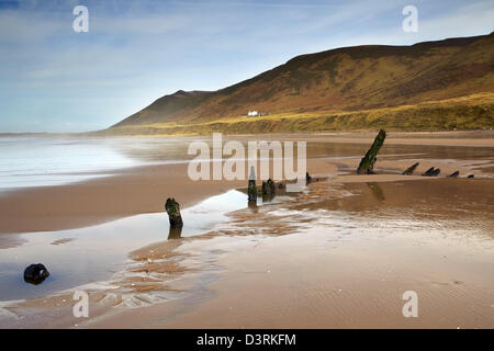 Helvetia wreck on Rhossili Bay, with Rhossili downs and the old Rectory behind, reflected in the wet sand. Winter. Stock Photo