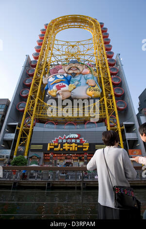 Don Quixote discount shop with Ferris wheel-like amusement park ride at Dotonbori River in Namba, Osaka. Stock Photo