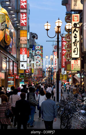 Neon lights of Dotonbori Street entertainment district in Namba, Osaka beckon visitors to enjoy lively atmosphere & restaurants. Stock Photo