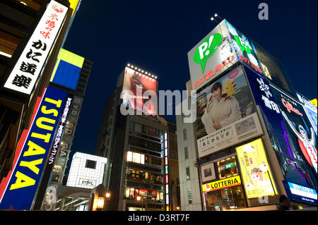 Advertising signs covering buildings along Ebisubashi-suji Avenue in Dotonbori entertainment district of Namba, Osaka at night. Stock Photo