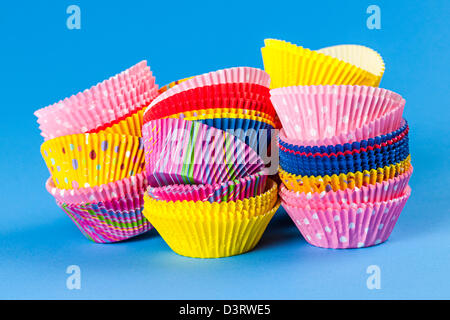 Several stacks of colorful muffin or cupcake cups on blue background Stock Photo