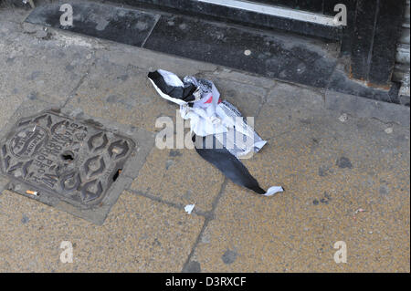 Wood Green, London, UK. 24th February 2013. A piece of the torn Nun picture found nearby. A new picture has appeared on the space where Banksy's 'Slave Labour' graffiti was on the side of Poundland in Wood Green. The picture of a nun pasted to the wall has already been partially ripped with a piece discarded nearby. A small figure of a man has also been painted onto the perspex covering the rat 'Why' picture.Credit: Matthew Chattle/Alamy Live News Stock Photo