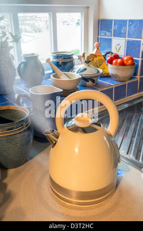 BOILING KETTLE WITH STEAM COMING FROM SPOUT IN COUNTRY KITCHEN UK Stock Photo