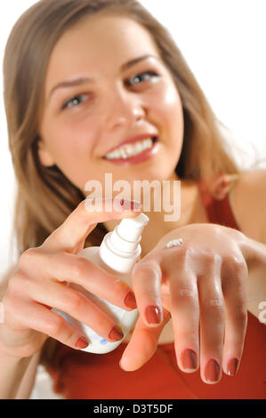 Young woman applies cream on her hands Stock Photo