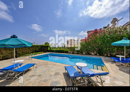 Umbrellas and sunbeds near the pool in the yard Stock Photo