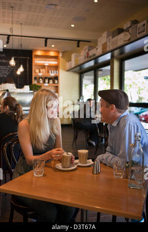 Young couple relaxing and drinking coffee in cafe. Canberra, Australian Capital Territory (ACT), Australia Stock Photo
