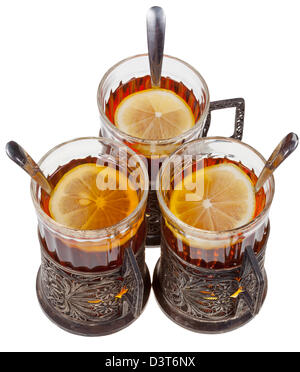 top view of three retro glasses in silver glass holders with black tea and lemon isolated on white background Stock Photo