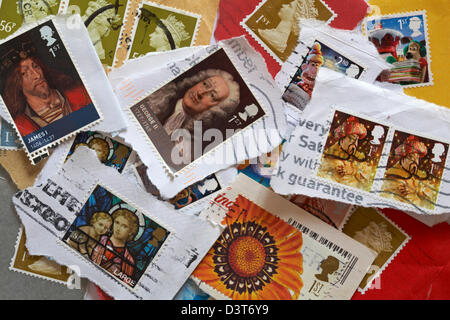 pile of used British postage stamps torn off envelopes and postcards Stock Photo
