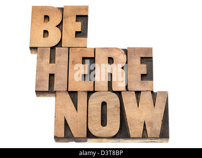 be here now - motivational and spiritual reminder- isolated text in vintage letterpress wood type printing blocks Stock Photo