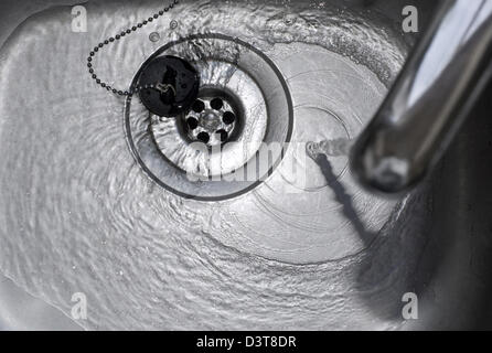 Water Running Down the Plughole in a stainless steel kitchen sink