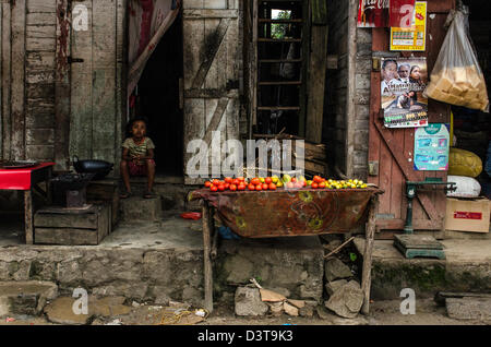 Child sitting outside the house Andasibe village or Perinet Madagascar Stock Photo