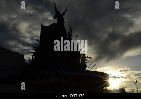 Quezon City, Manila, Philippines. 25th February 2013.  The sun silhouettes the EDSA People Power Monument  during the commemoration of the 27th People Power Revolution on Monday, February 25. The People Power Revolution is a significant event in Philippine History, marking the return of democracy in the country from a dictatorship under the Marcos regime in a bloodless uprising of the Filipino people. (Photo by Mark Demayo/Alamy Live News) Stock Photo