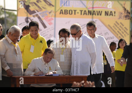 Quezon City, Manila, Philippines. 25th February 2013.  President Benigno Aquino III (sitting) signs into law the Human Rights Victims Reparation and Recognition Act of 2013, which grants reparation for human rights violations during the Martial Law rule of former president Ferdinand Marcos, during the commemoration of the 27th People Power Revolution on Monday, February 25. (Photo by Mark Demayo/Alamy Live News) Stock Photo