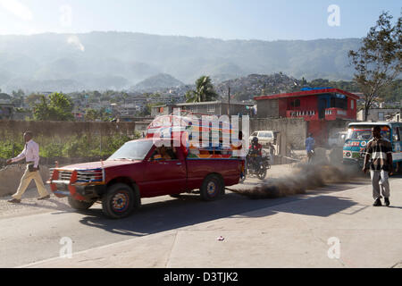 Tap-tap buses passing through the downtown of Port-au-Prince. Tap-tap vehicles serve as public transportation in Haiti. Stock Photo