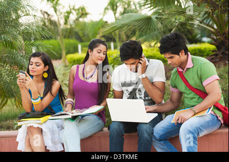 University students using a laptop and mobile phones in university campus Stock Photo