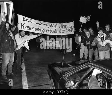 (dpa - files) Around 1.000 citizens of the GDR greet visitors from West Germany with a poster 'Erst wir, jetzt Ihr - Kreuz und quer durch die DDR' (Lit. 'First we, now you - All across the GDR') at the motorway border crossing point Gudow-Zarrentin in Germany, 24 December 1989. Many West German citizens payed return visits to East German relatives and friends after the partial open Stock Photo